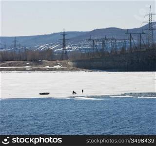 fishermen on the ice fishing in winter on the river