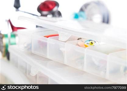fishing baits and lure in transparent plastic storage boxes on bright white background. for design advertising or publication