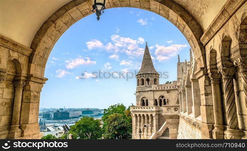Fishing Bastion and Budapest at summer evening, view through arch. Fishing Bastion in Budapest