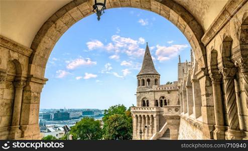 Fishing Bastion and Budapest at summer evening, view through arch. Fishing Bastion in Budapest