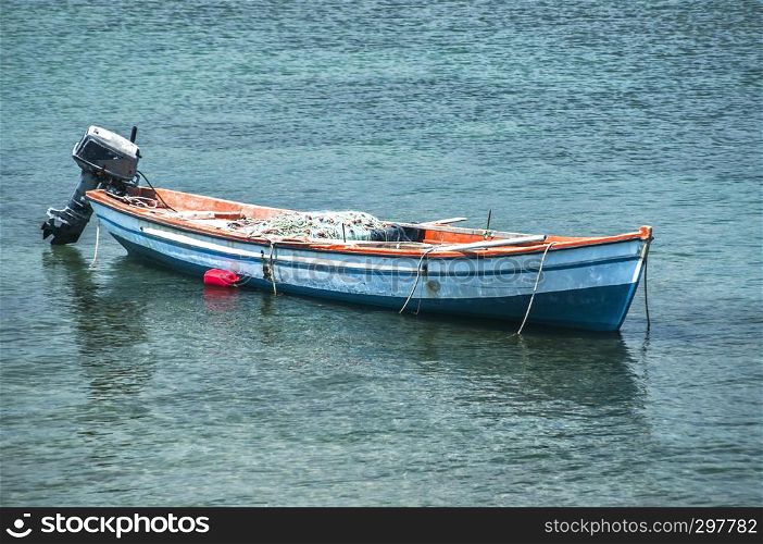 Fishing boat anchored in calm blue sea waters closeup in sunny summer day