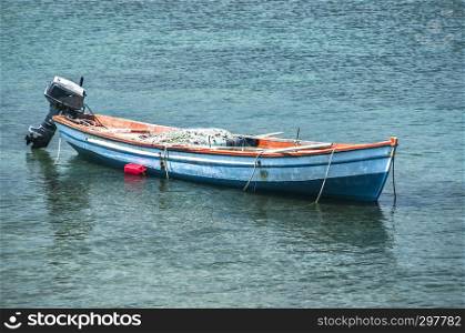 Fishing boat anchored in calm blue sea waters closeup in sunny summer day