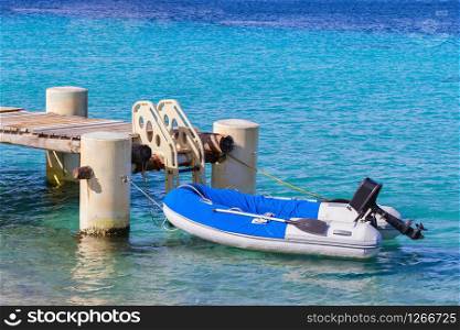 Fishing boat floating on sea near pier with stairs