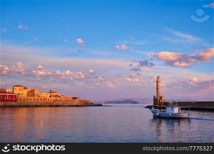 Fishing boat going to sea in picturesque old port of Chania is one of landmarks and tourist destinations of Crete island in the morning. Chania, Crete, Greece. Boat in picturesque old port of Chania, Crete island. Greece