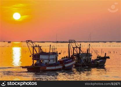 Fishing boat in a harbor with sunset in holiday
