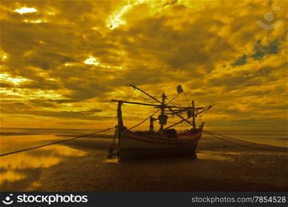 Fishing boat on the beach and sunset