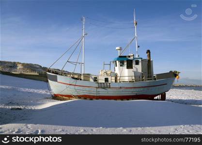 Fishing boat on the beach in winter