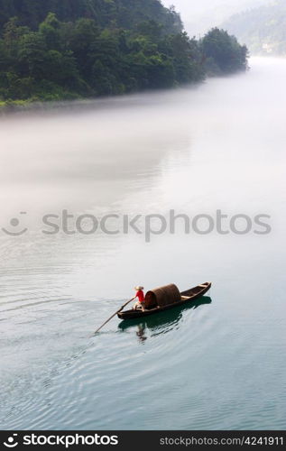 Fishing boat on the foggy river, photo taken in hunan province of China