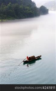 Fishing boat on the foggy river, photo taken in hunan province of China