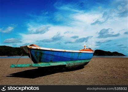 Fishing boat on the shore with blue sky.