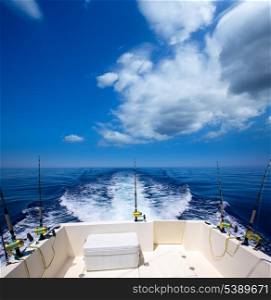 Fishing boat stern deck with trolling fishing rods and reels in blue ocean sea