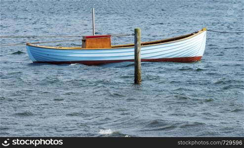 Fishing boat tethered to post in baltic sea horizontal panorama