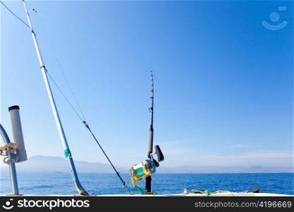 fishing boat trolling with outrigger gear and golden reel rod