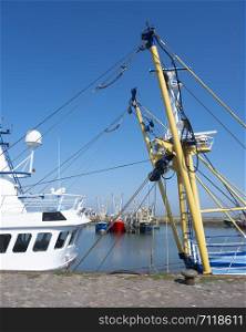 fishing boats in harbor of lauwersoog in the north of groningen in the netherlands on sunny summer day under blue sky