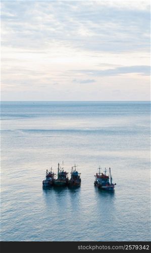 Fishing boats in sea In the morning calm ocean waves. And the sky started to morning