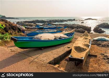 fishing boats with nets by the ocean