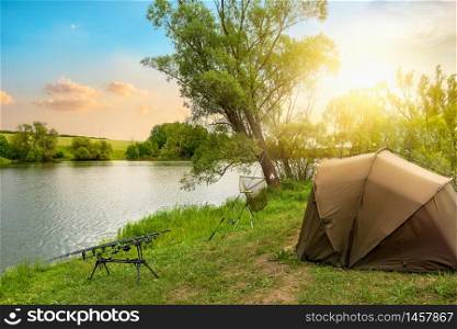 Fishing camp on a river bank at sunset. Fishing camp at sunset