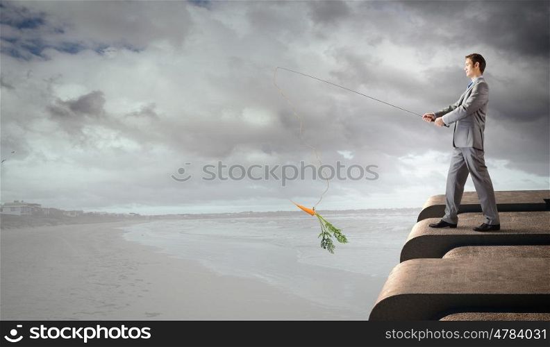 Fishing concept. Businessman standing on top of building and fishing with rod
