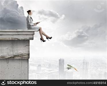 Fishing concept. Businesswoman fishing with rod on top of building
