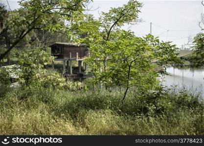 Fishing huts on the Pialassa della Baiona brackish lagoon near Marina Romea along the Adriatic seaside in Ravenna (Italy)
