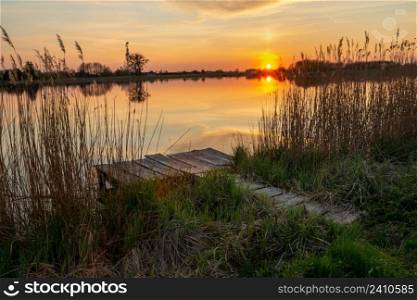 Fishing pier on the shore of the lake and sunset, Stankow, Lubelskie, Poland