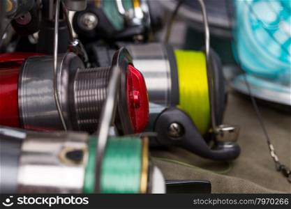 fishing reels with line different colors on cloth background