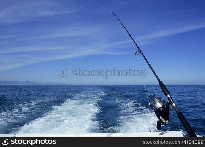 Fishing rod and reel on a boat, vacation on blue sea and summer sky