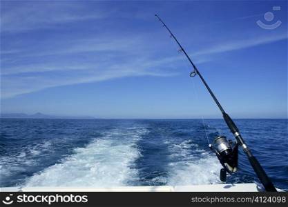 Fishing rod and reel on a boat, vacation on blue sea and summer sky