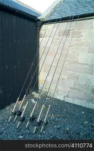 Fishing rods lean against building exterior, Scotland