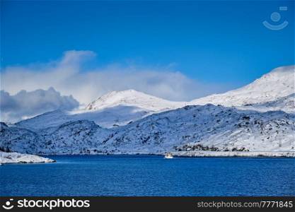 Fishing ship boat in Norwegian fjord in winter. Lofoten islands, Norway. Fishing ship in fjord in Norway
