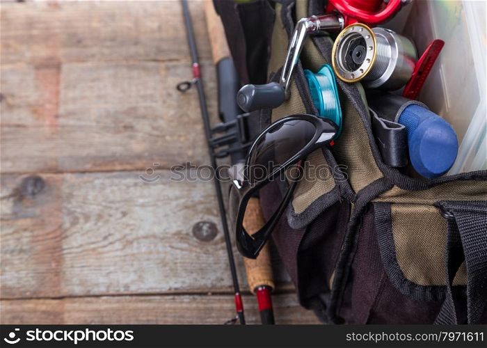 fishing tackles and lures in open handbag on wooden background. for design advertising or publication