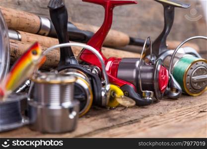 fishing tackles different rod and reel on timber board background. for design advertising or publication