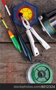 fishing tackles for anglers - swimmers, plummets and tools on wooden background