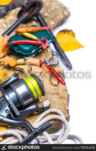 fishing tackles on stones with anchor and leafs on white background