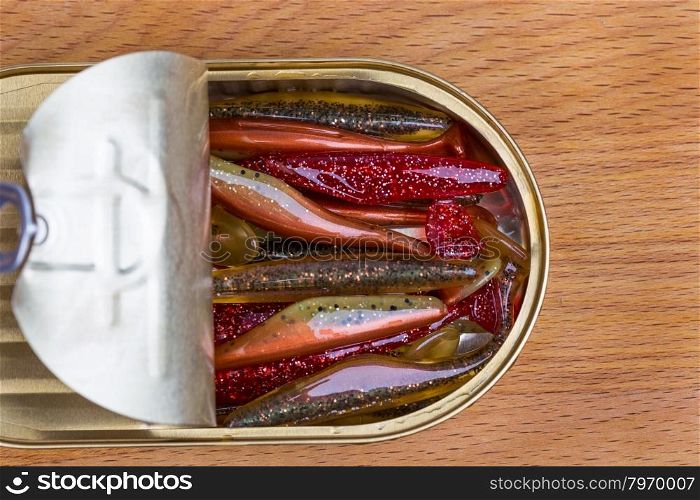 fishing tackles Swimbait different colors in open can on wood background