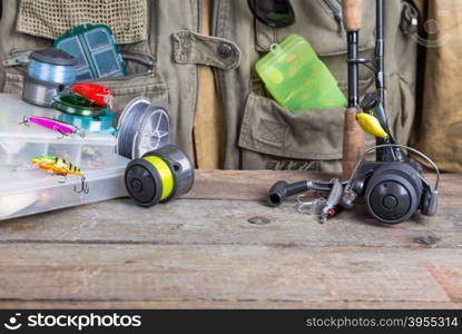 fishing tackles with fishing vest and wooden boards. design background for outdoor advertisement, flayer etc.