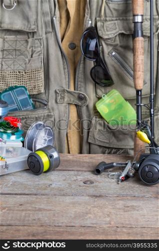 fishing tackles with fishing vest and wooden boards. design background for outdoor advertisement, flayer etc.