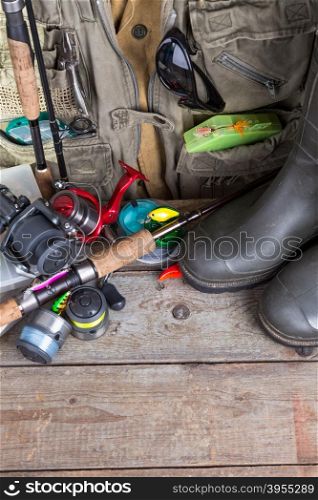 fishing tackles with fishing vest, boots and wooden boards. design background for outdoor advertisement, flayer etc.