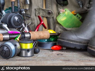 fishing tackles with fishing vest, boots and wooden boards. design background for outdoor advertisement, flayer etc.