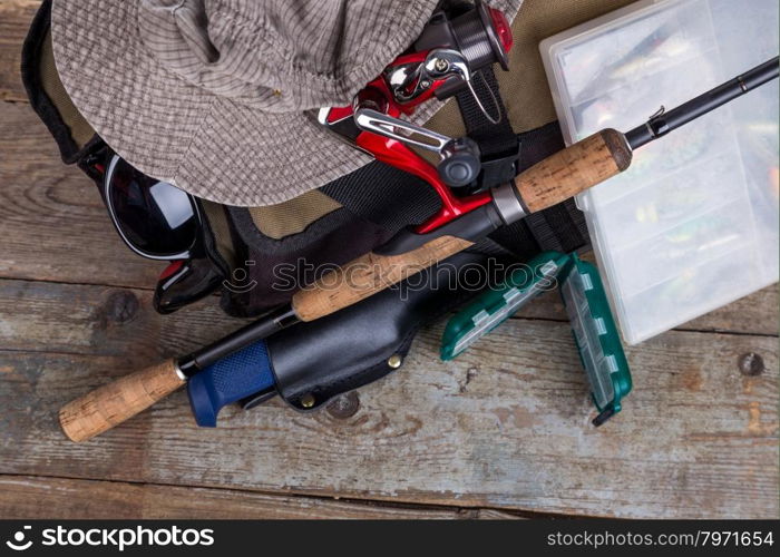 fishing tackles with handbag and hat on wooden background. for design advertising or publication