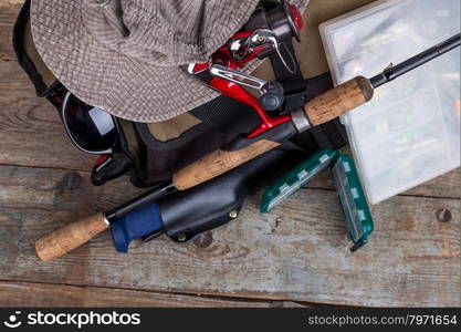 fishing tackles with handbag and hat on wooden background. for design advertising or publication