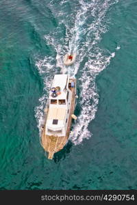 Fishing trawler on blue sea aerial vertical view