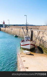 fishing trawler with his tender boat on the hold of the port of Erquy in Brittany
