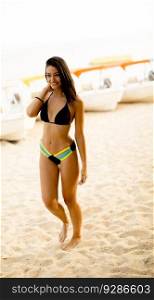 Fit and sporty woman in a swimsuit relaxing on a beach at summer