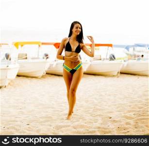 Fit and sporty woman in a swimsuit relaxing on a beach at summer