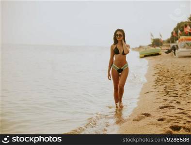 Fit and sporty young woman in a swimsuit relaxing on a beach at summer