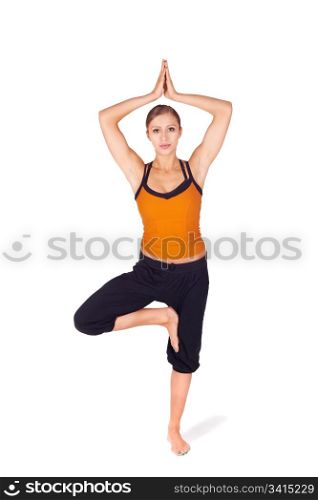 Fit attractive young woman practicing yoga exercise called Tree Pose, sanskrit name: Vrksasana, this pose strengthen thighs, calves, ankles and back, improves balance and concentration