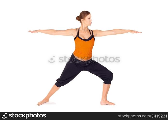 Fit attractive young woman practicing yoga exercise called Warrior Pose 2, sanskrit name: Virabhadrasana 2, this posture strengthens and stretches legs, ankles, groins, chest, lungs and shoulders