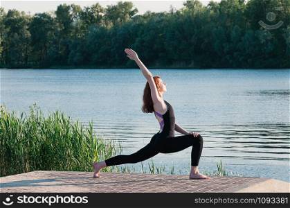 Fit beautiful woman practice yoga, outdoor, summer riverside background. Physical and internal healthcare. Healthy lifestyle, keep fit, weight loss, enjoy life. Strengthen mind and body concept