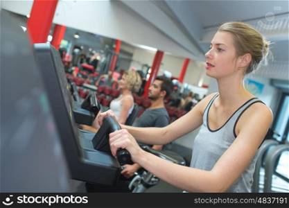 fit blonde using the step machine at the gym